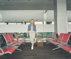 A young woman with her luggage at the airport.