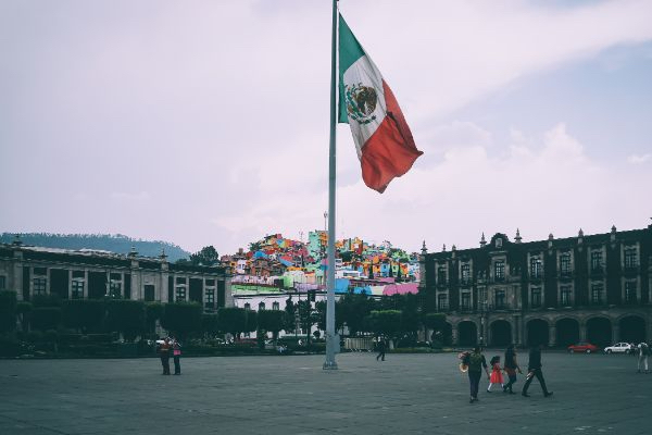 people walking around the Mexican flag in Toluca de Lerdo, Méx., Mexico