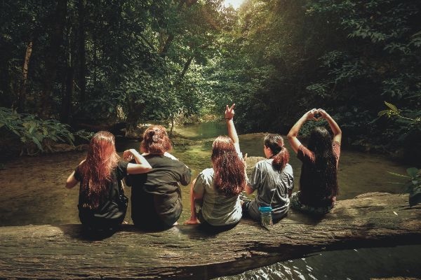five women sitting on a tree trunk in Thailand