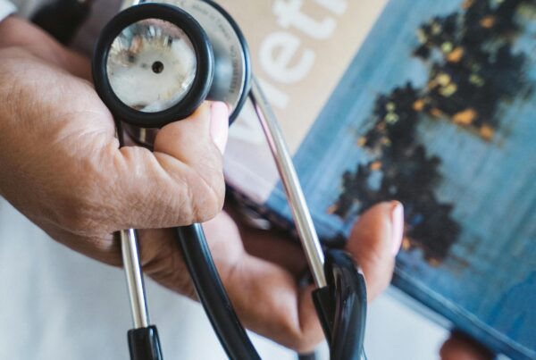 A stethoscope being held up above a Vietnam book.
