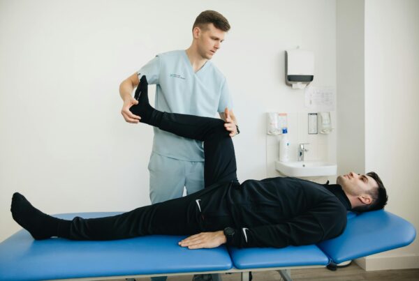 A physical therapist stretching out a patients legs.
