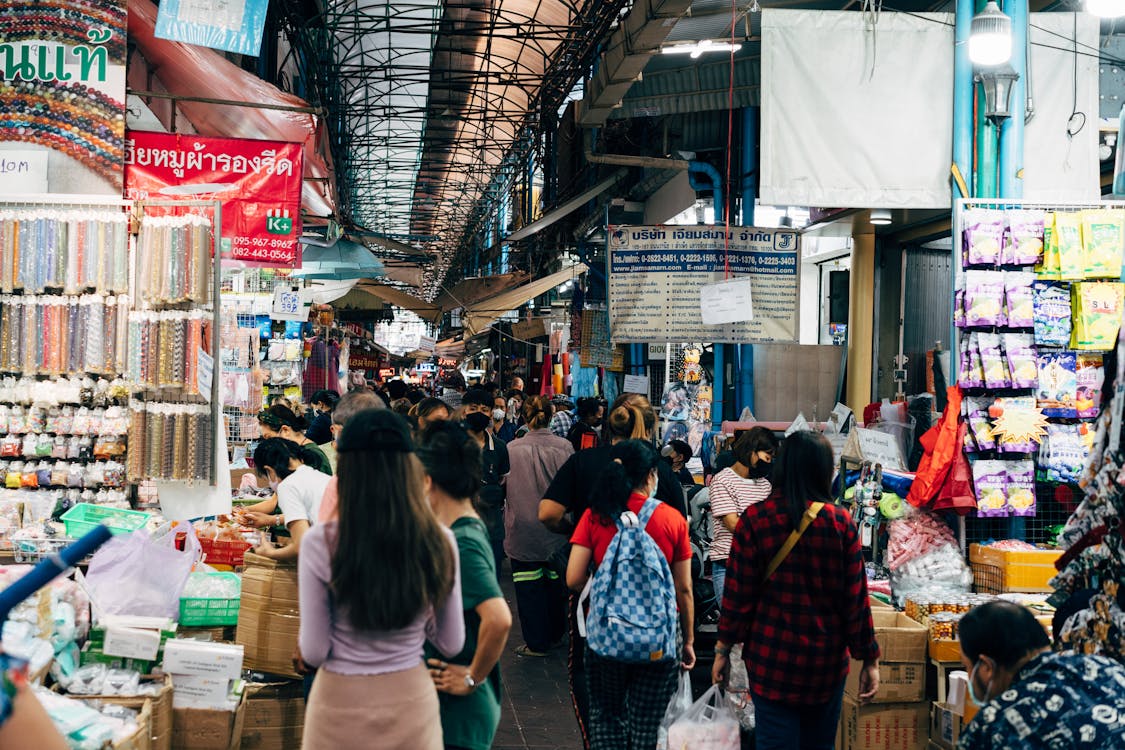 Crowd of shoppers exploring a busy indoor market in Thailand