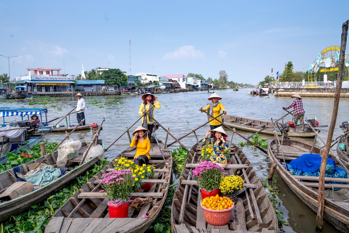Women selling flowers on boats at a floating market in Vietnam