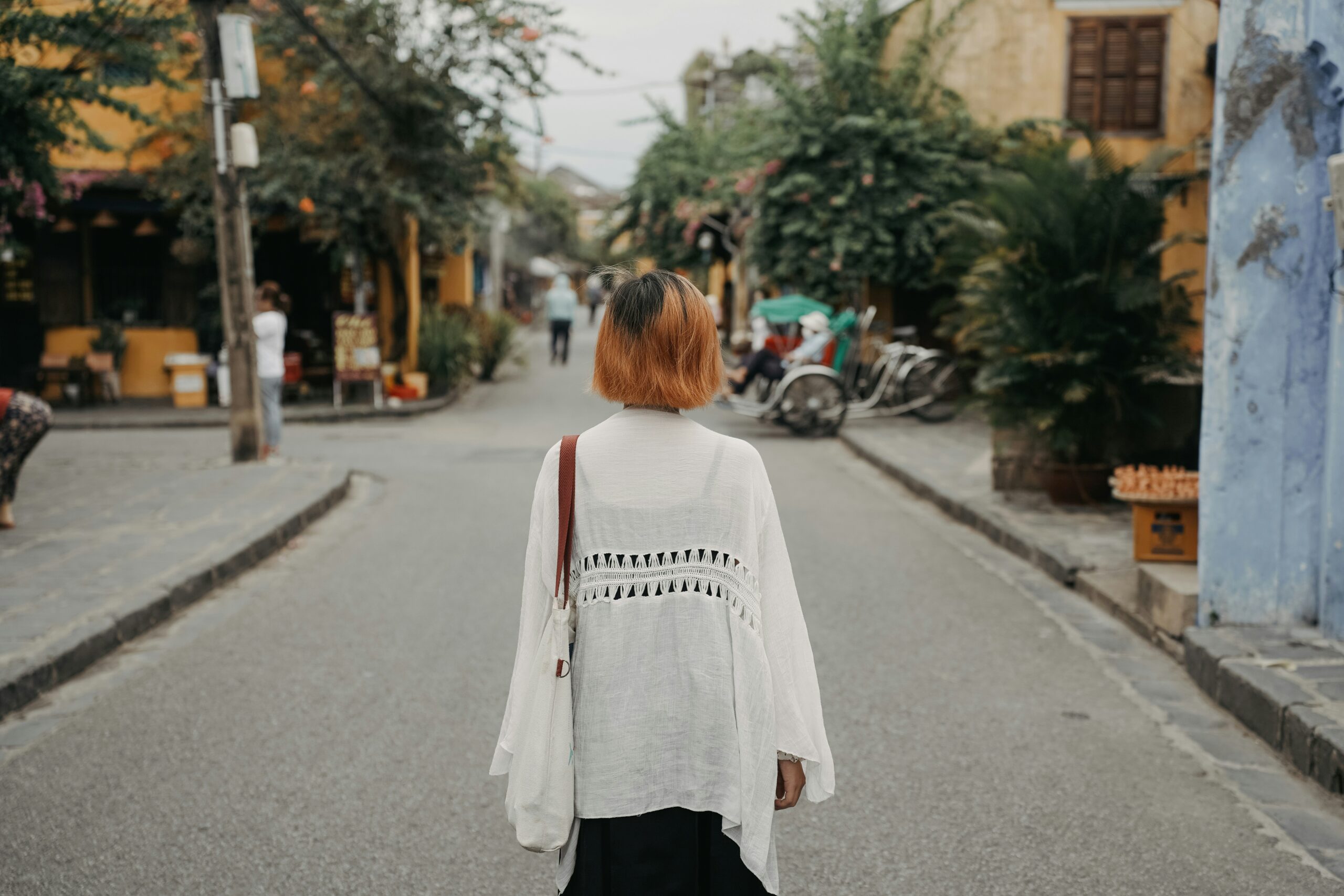 A woman walks down a quiet, charming street