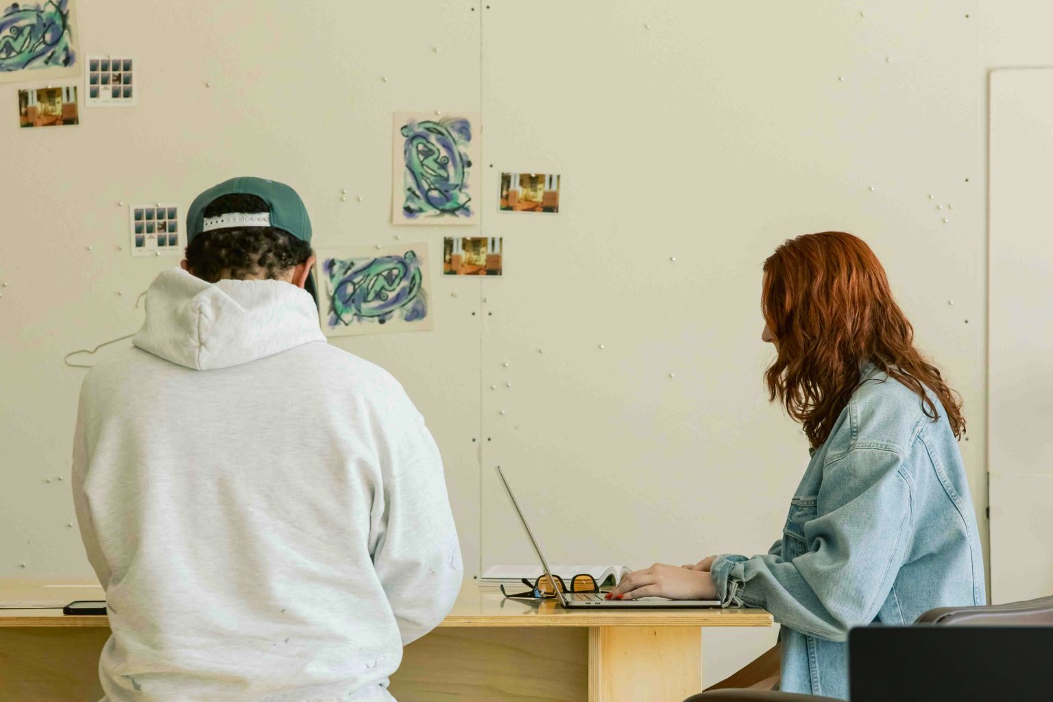 Woman drawing at a desk filled with art tools