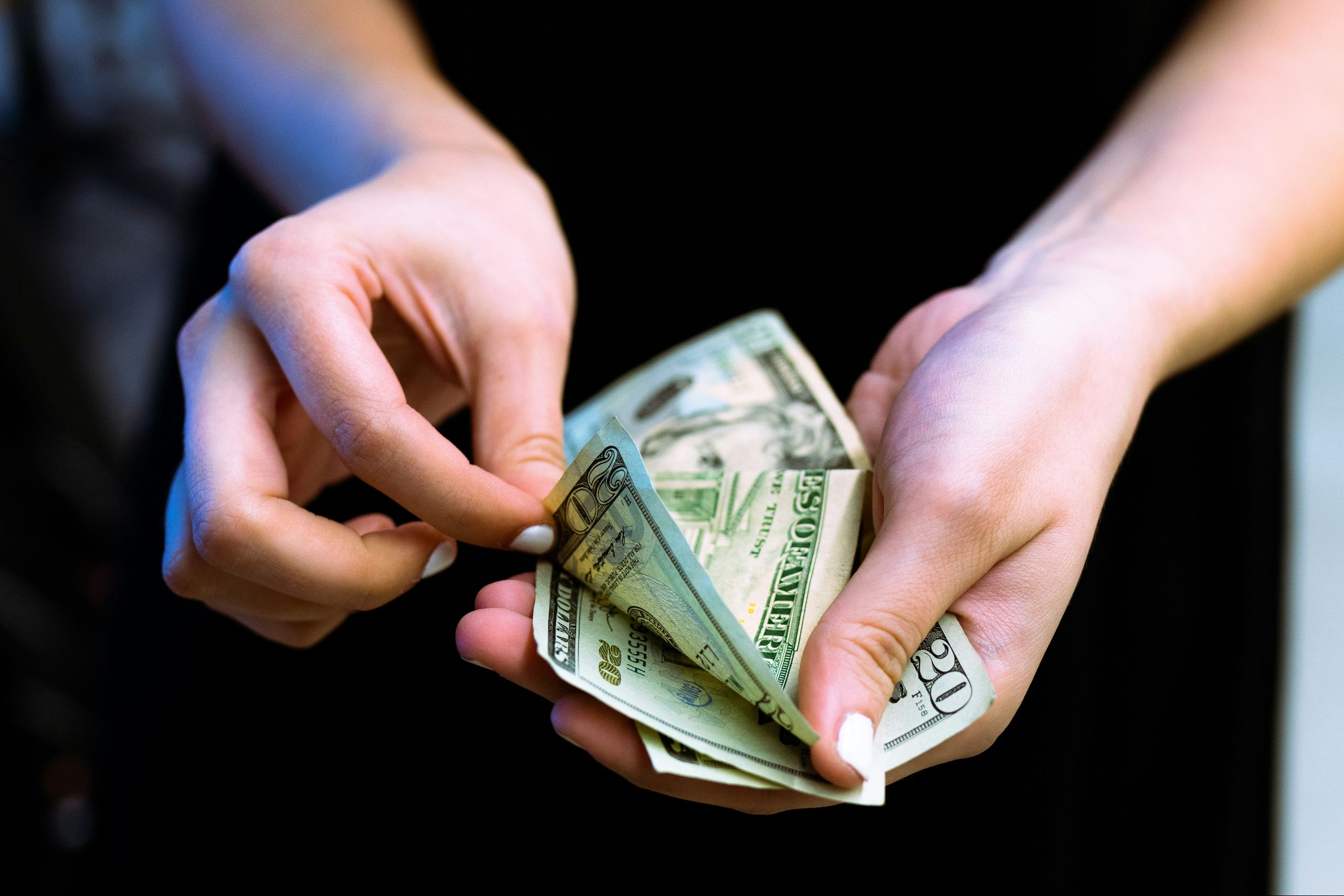 Hands holding and counting U.S. dollar bills