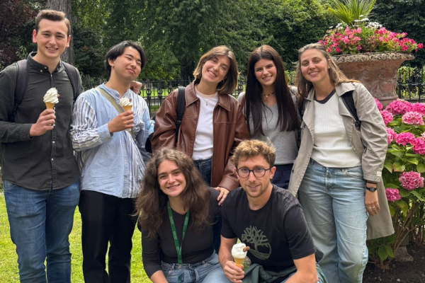 A group of seven people smiling. Three are holding ice cream cones.