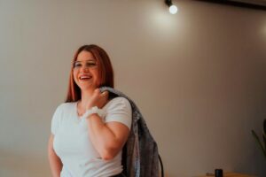 Woman holding a jacket over her shoulder.