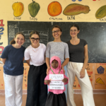 Carlotta and three other volunteers posing with a student.