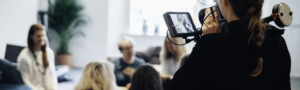 A woman using a video camera to record a conversation.