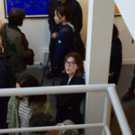 Elena surrounded by people indoors.