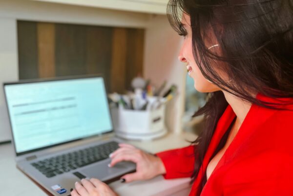 A woman working on a laptop at a desk.