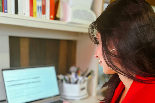 A woman working on a laptop at a desk.