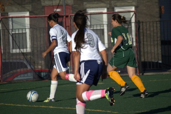 Three girls playing soccer.
